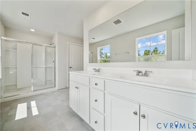 a spacious bathroom with double sink and a bathtub