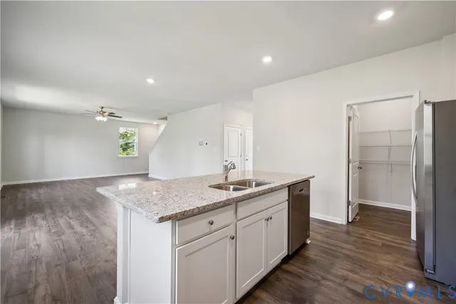 a kitchen with a granite countertop sink and refrigerator