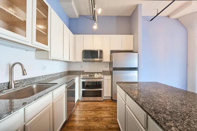 a view of a kitchen with wooden floor and a kitchen