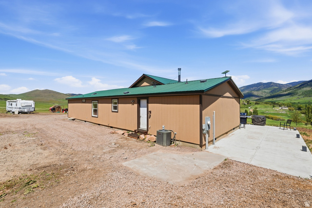 8066 North Valley View Heights Preston, ID 83263 - Photo 26 of 34 Wood-sided exterior featuring a green metal roof and white trim windows