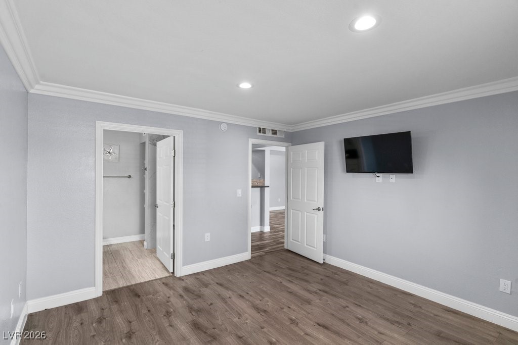 7885 West Flamingo Road, Unit 1053 Las Vegas, NV 89147 - Photo 16 of 33 Unfurnished bedroom featuring crown molding, wood finished floors, recessed lighting, and connected bathroom