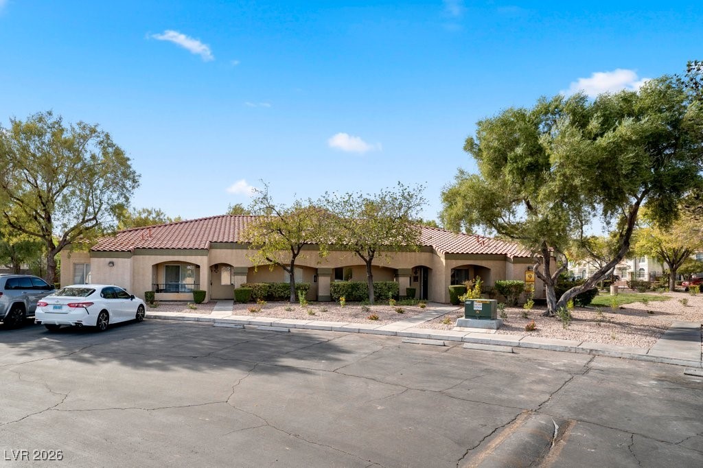 7885 West Flamingo Road, Unit 1053 Las Vegas, NV 89147 - Photo 30 of 33 Mediterranean / spanish home with stucco siding, a tiled roof, and uncovered parking