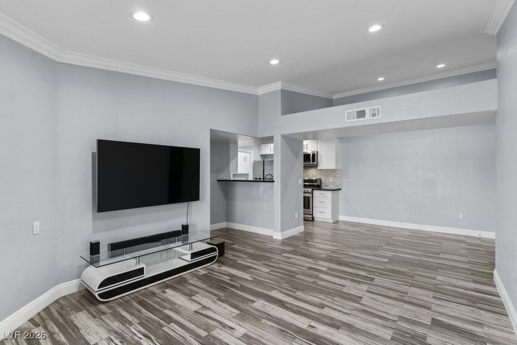 7885 West Flamingo Road, Unit 1053 Las Vegas, NV 89147 - Photo 8 of 33 Living area with crown molding, recessed lighting, and light wood-style flooring