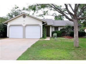 a view of a white house with a big yard and large tree