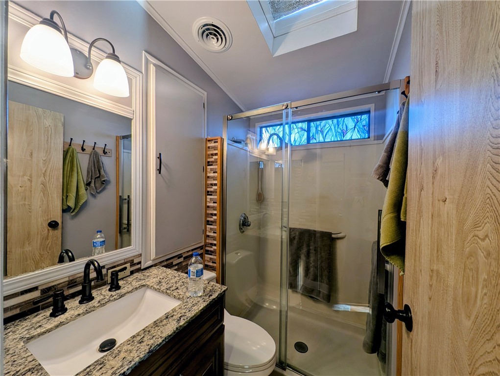 2000 Ramar Road, Unit 89 Bullhead City, AZ 86442 - Photo 25 of 26 Bathroom with ornamental molding, vanity, a shower stall, and a skylight