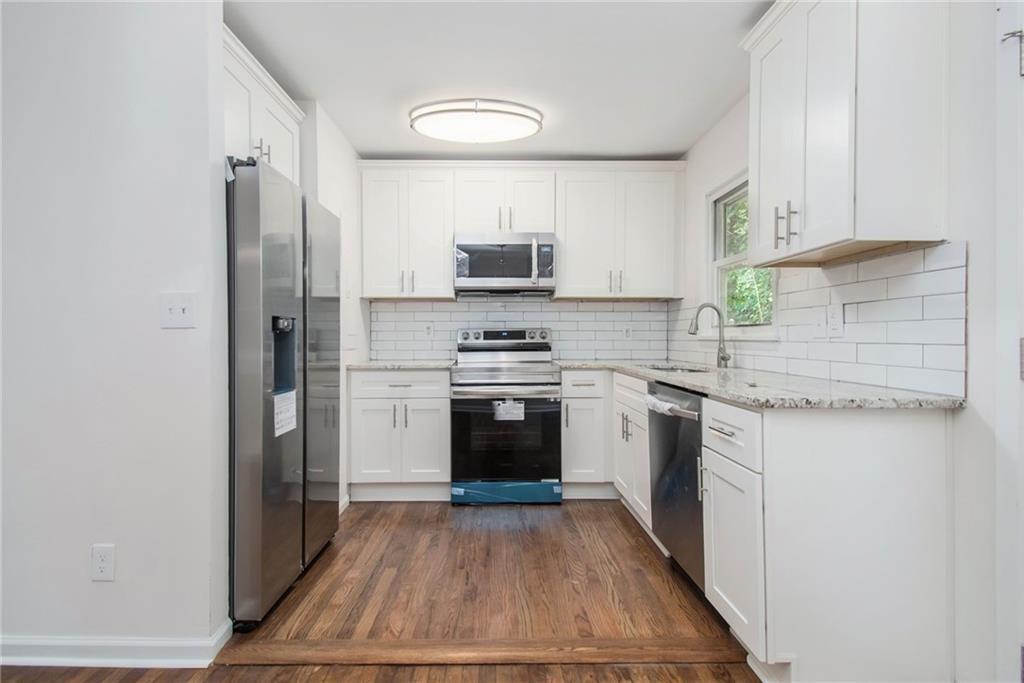 980 Fairburn Road Northwest Atlanta, GA 30331 - Photo 2 of 8 a kitchen with white cabinets and stainless steel appliances