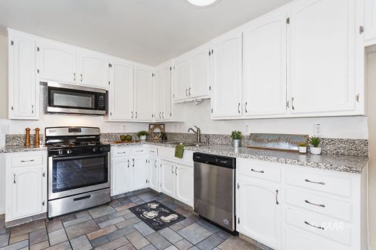 640 Sydnor Avenue Ridgecrest, CA 93555 - Photo 11 of 28 a kitchen with granite countertop white cabinets and stainless steel appliances