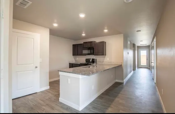 a large kitchen with stainless steel appliances granite countertop a sink a stove top oven a counter space and cabinets