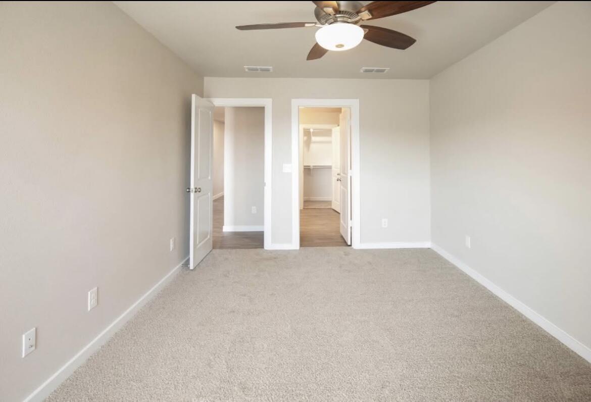 2405 144th Street, Unit A Lubbock, TX 79423 - Photo 7 of 13 an empty room with a ceiling fan and a window