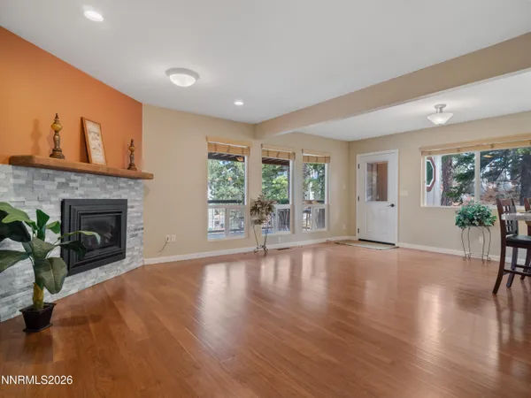 an empty room with wooden floor and a fireplace