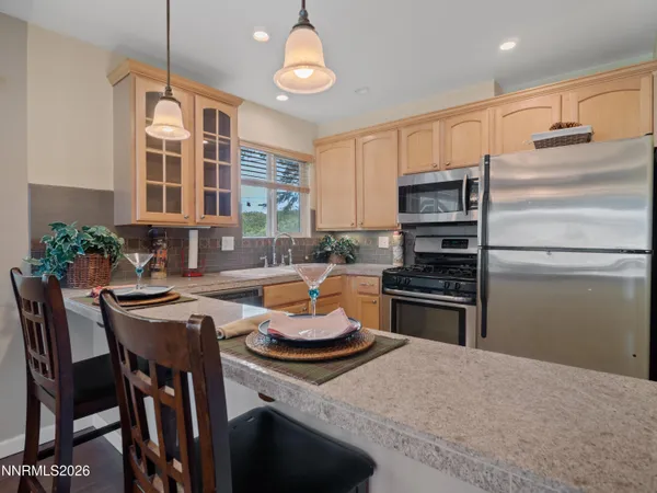 a kitchen with stainless steel appliances granite countertop a refrigerator sink stove microwave and cabinets