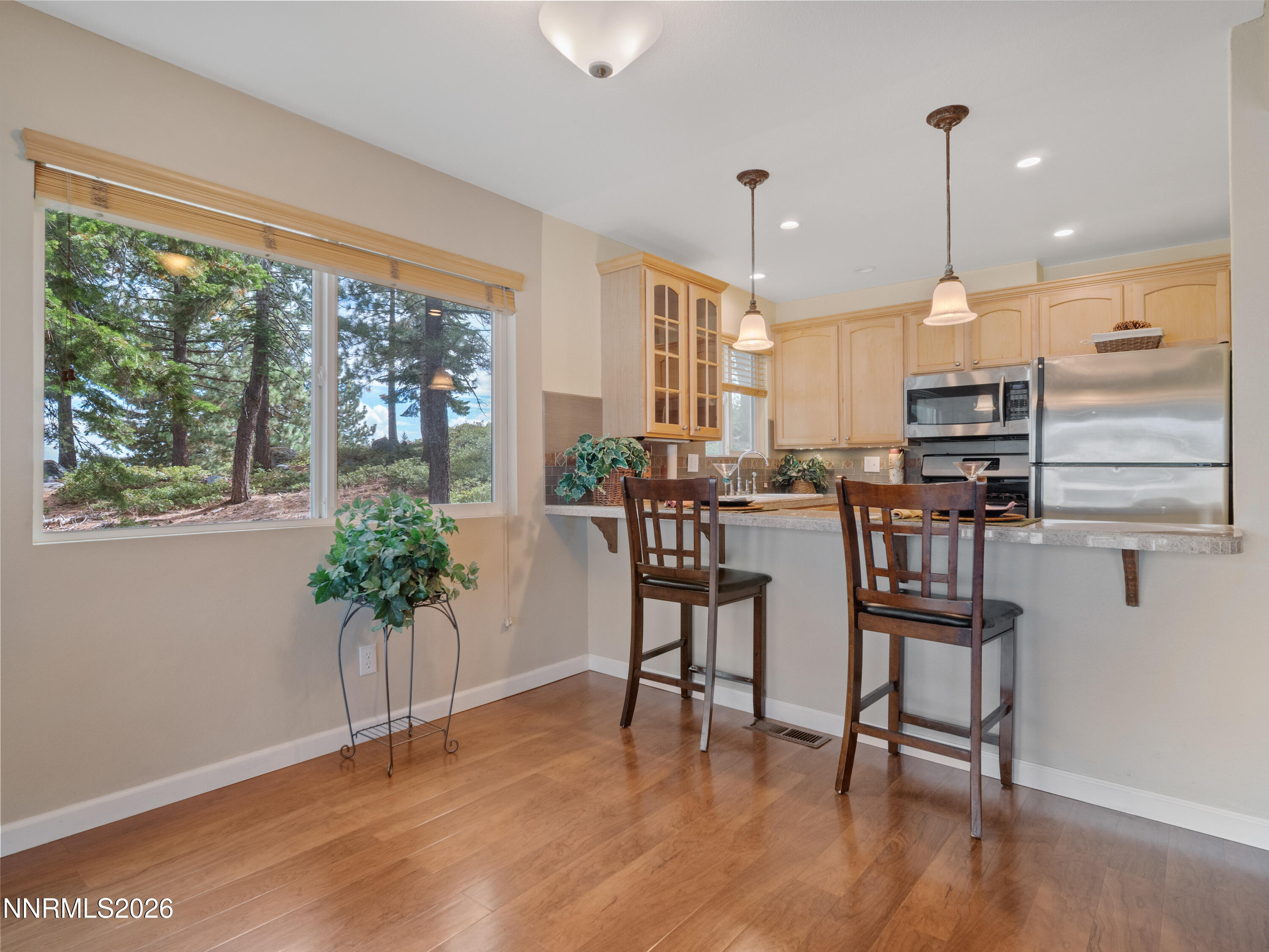 761 Milky Way Court, Unit A Stateline, NV 89449 - Photo 9 of 43 a kitchen with stainless steel appliances granite countertop wooden floor dining table and chairs