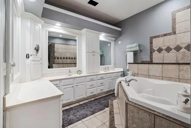 a bathroom with a tub sink and mirror