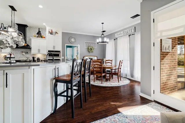 a view of a a dining room with furniture window and wooden floor