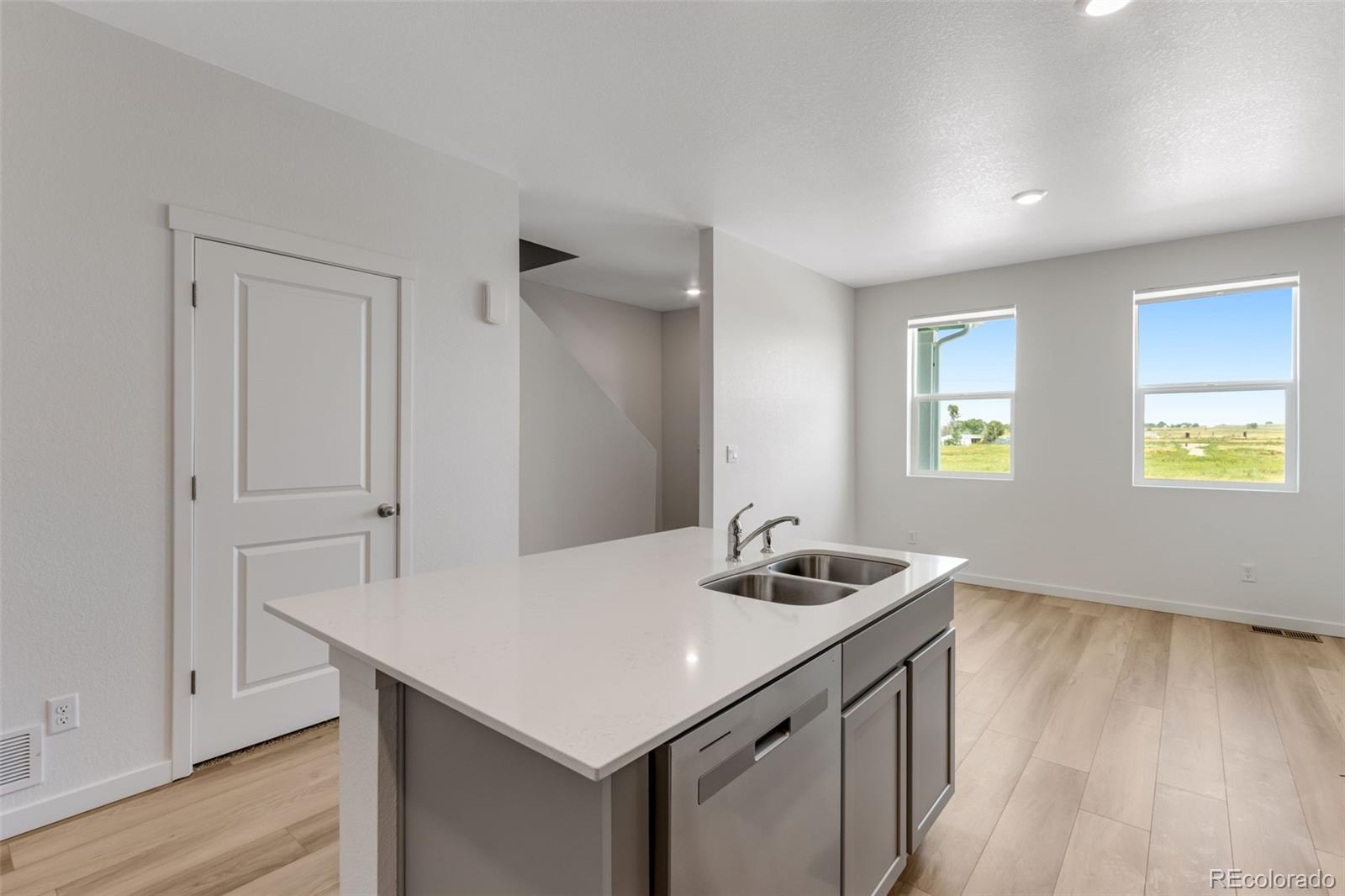 2403 Pinot Place Fort Lupton, CO 80621 - Photo 6 of 20 a kitchen that has a sink a window and wooden floor