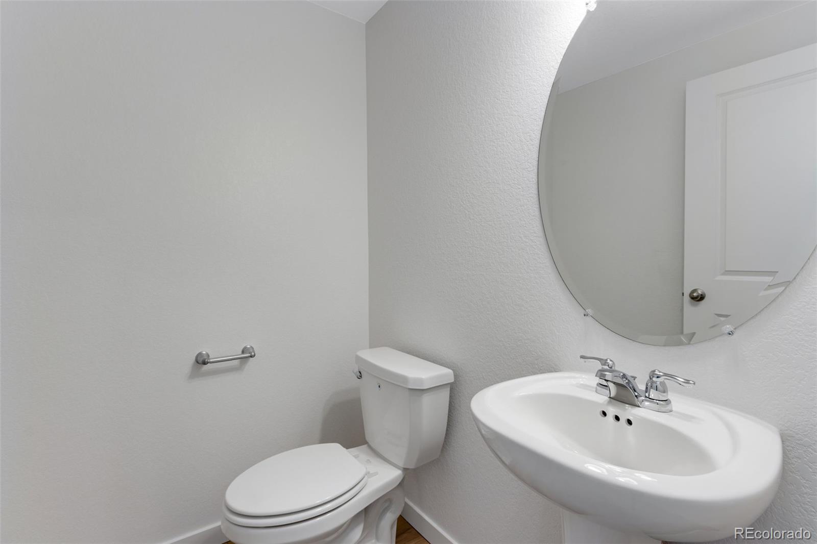2403 Pinot Place Fort Lupton, CO 80621 - Photo 10 of 20 a white toilet sitting next to a bathroom sink