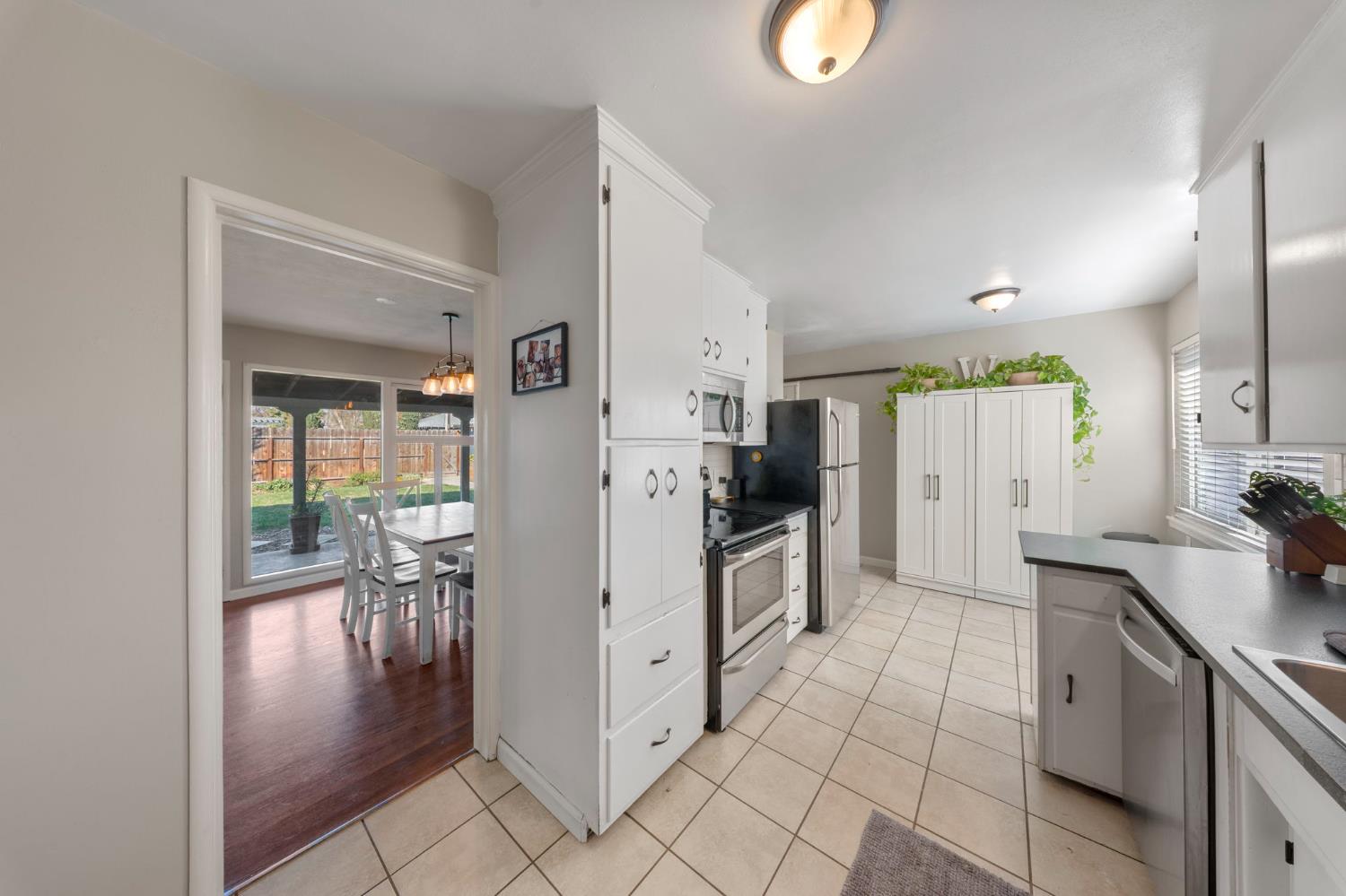 1405 Fordham Avenue Modesto, CA 95350 - Photo 13 of 32 a kitchen with granite countertop a refrigerator and a sink
