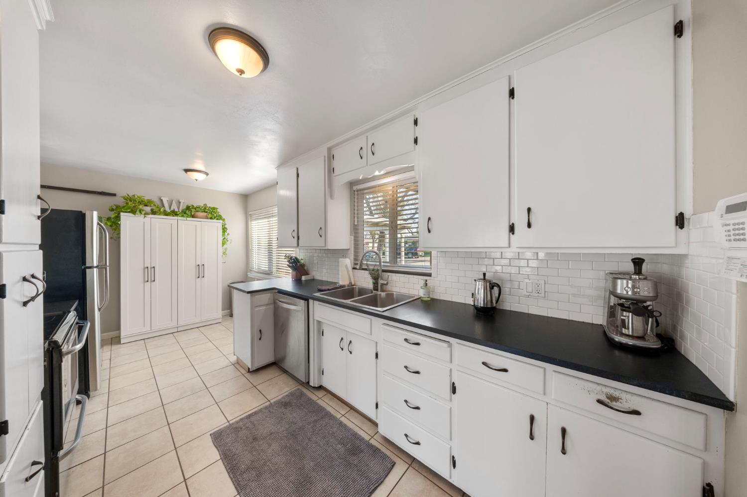 1405 Fordham Avenue Modesto, CA 95350 - Photo 14 of 32 a kitchen with stainless steel appliances granite countertop a sink and cabinets
