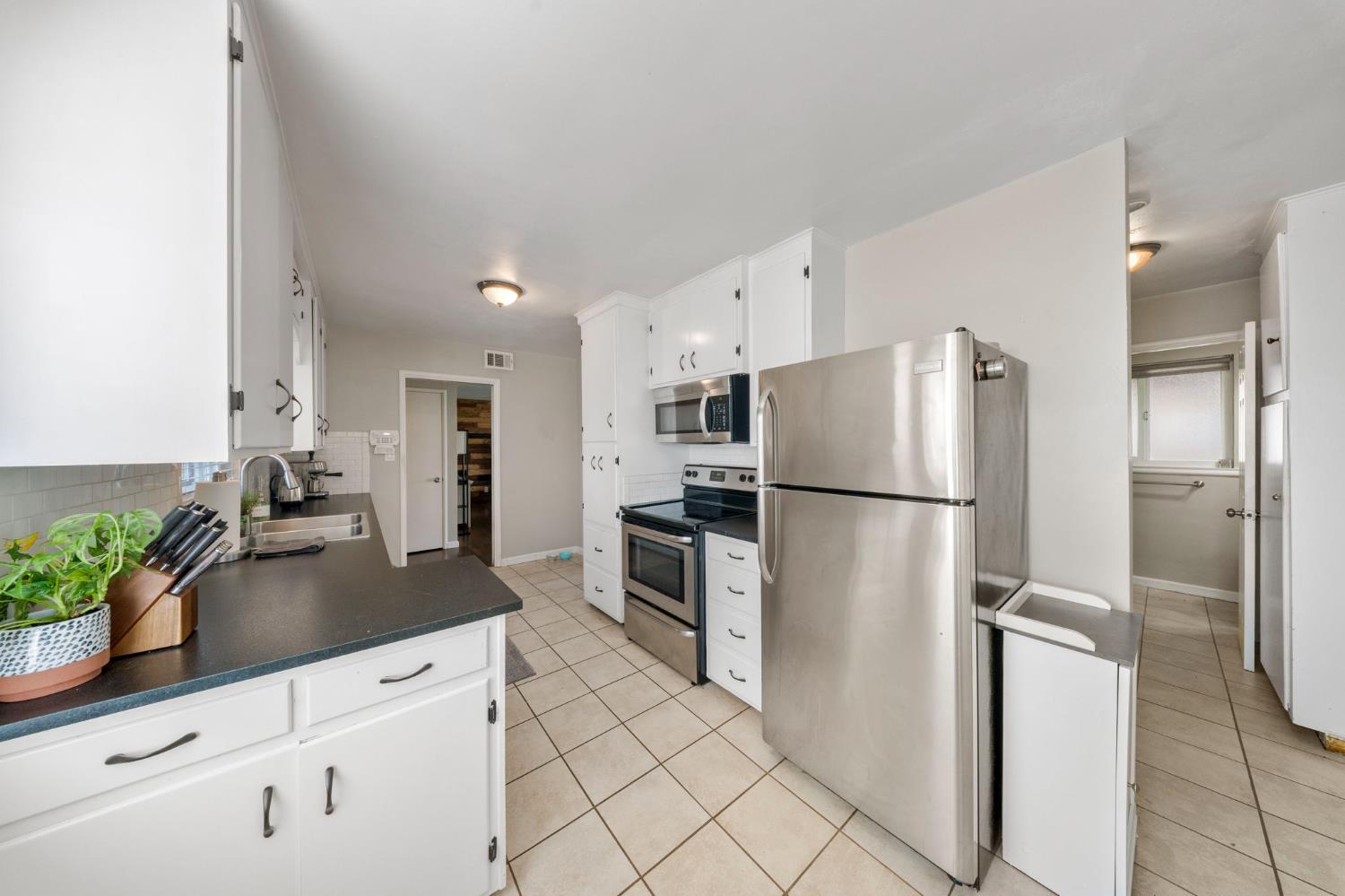 1405 Fordham Avenue Modesto, CA 95350 - Photo 15 of 32 a kitchen with stainless steel appliances a refrigerator sink and microwave