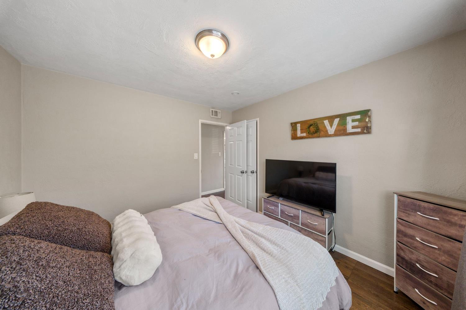 1405 Fordham Avenue Modesto, CA 95350 - Photo 20 of 32 a bedroom with a bed and a flat screen tv