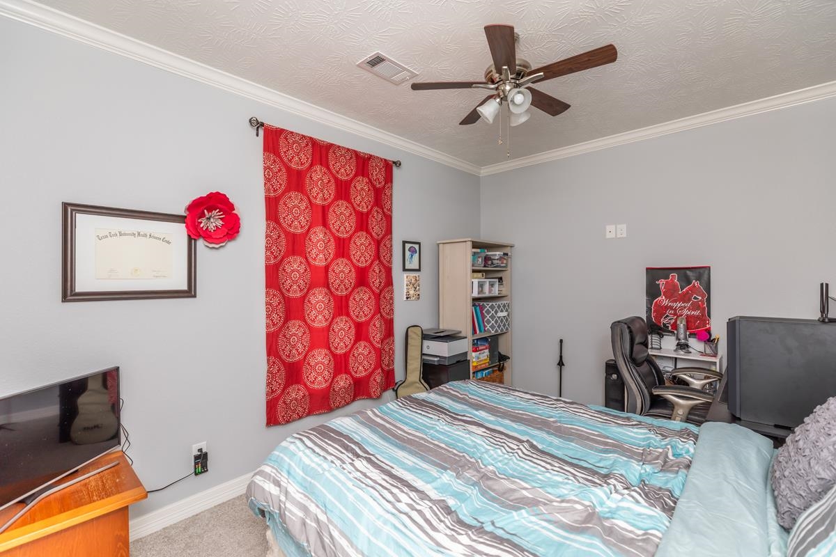 314 Long Leaf Street Silsbee, TX 77656 - Photo 20 of 31 a bedroom with a bed and a chandelier