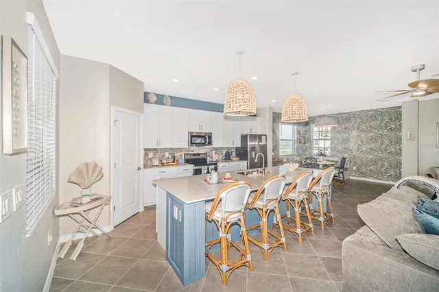 a living room with furniture a flat screen tv and a large window