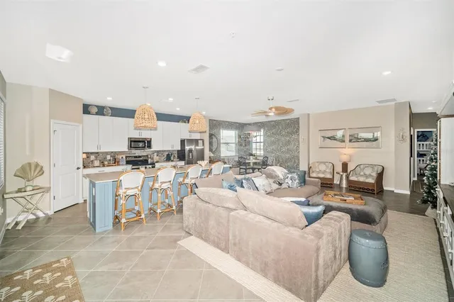 a kitchen with kitchen island a stove a refrigerator and a sink with living room