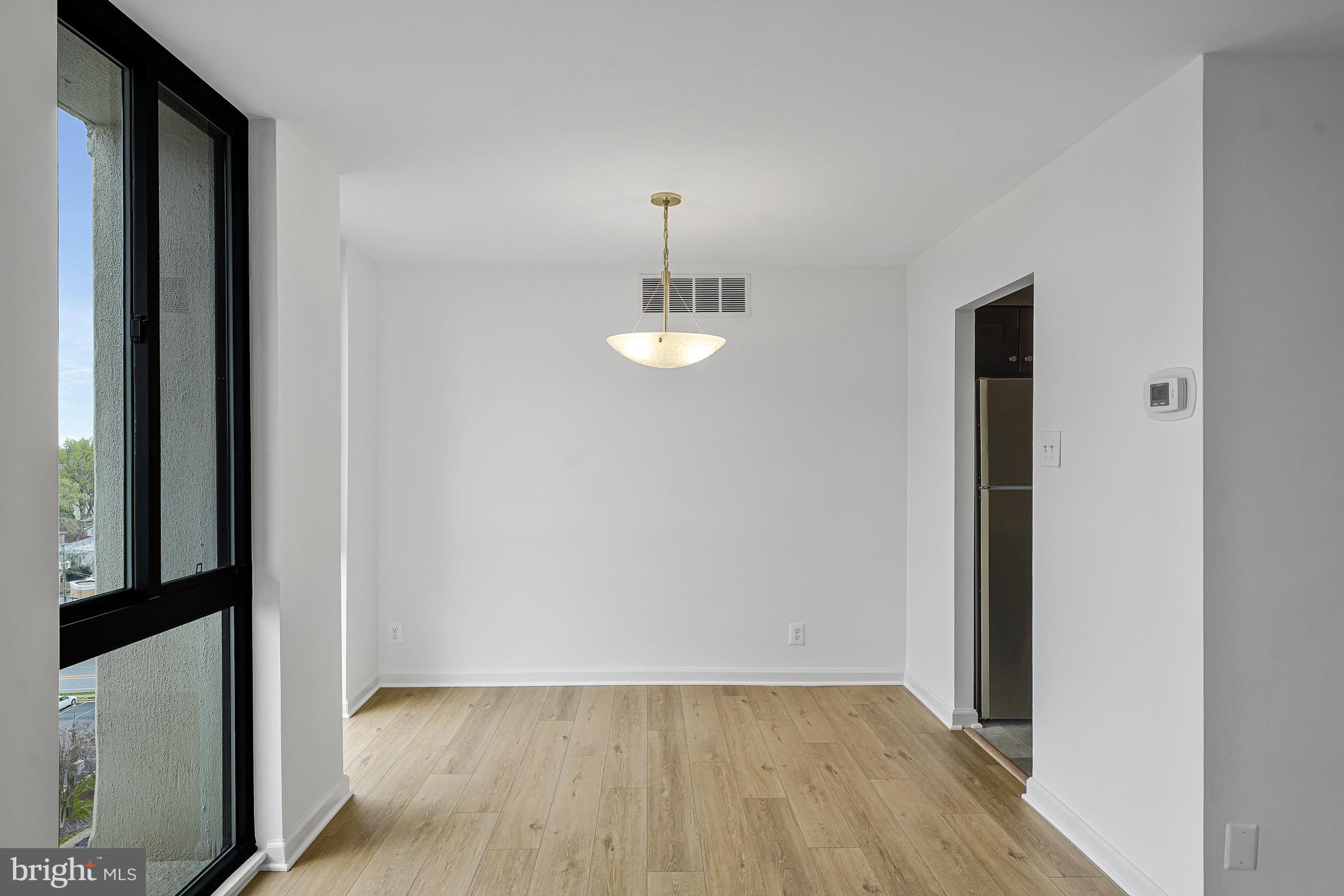 6800 Fleetwood Road, Unit 1013 McLean, VA 22101 - Photo 8 of 32 an empty room with wooden floor mirror and windows