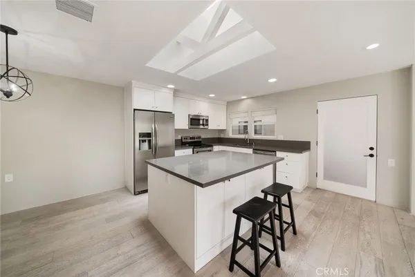 a kitchen with kitchen island a sink stainless steel appliances and cabinets