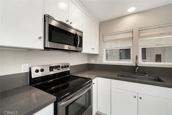 a kitchen with granite countertop a sink and a stove top oven
