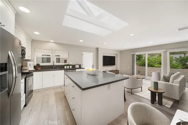 a kitchen with stainless steel appliances granite countertop a table chairs refrigerator and microwave