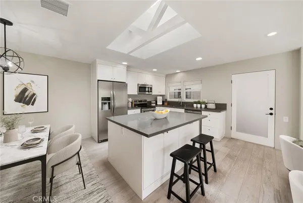 a kitchen with stainless steel appliances kitchen island granite countertop a refrigerator and a stove top oven