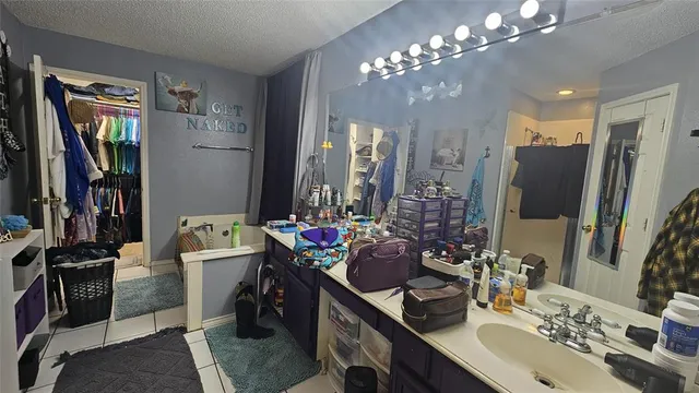 a bathroom with double vanity sink a toilet a mirror and shower