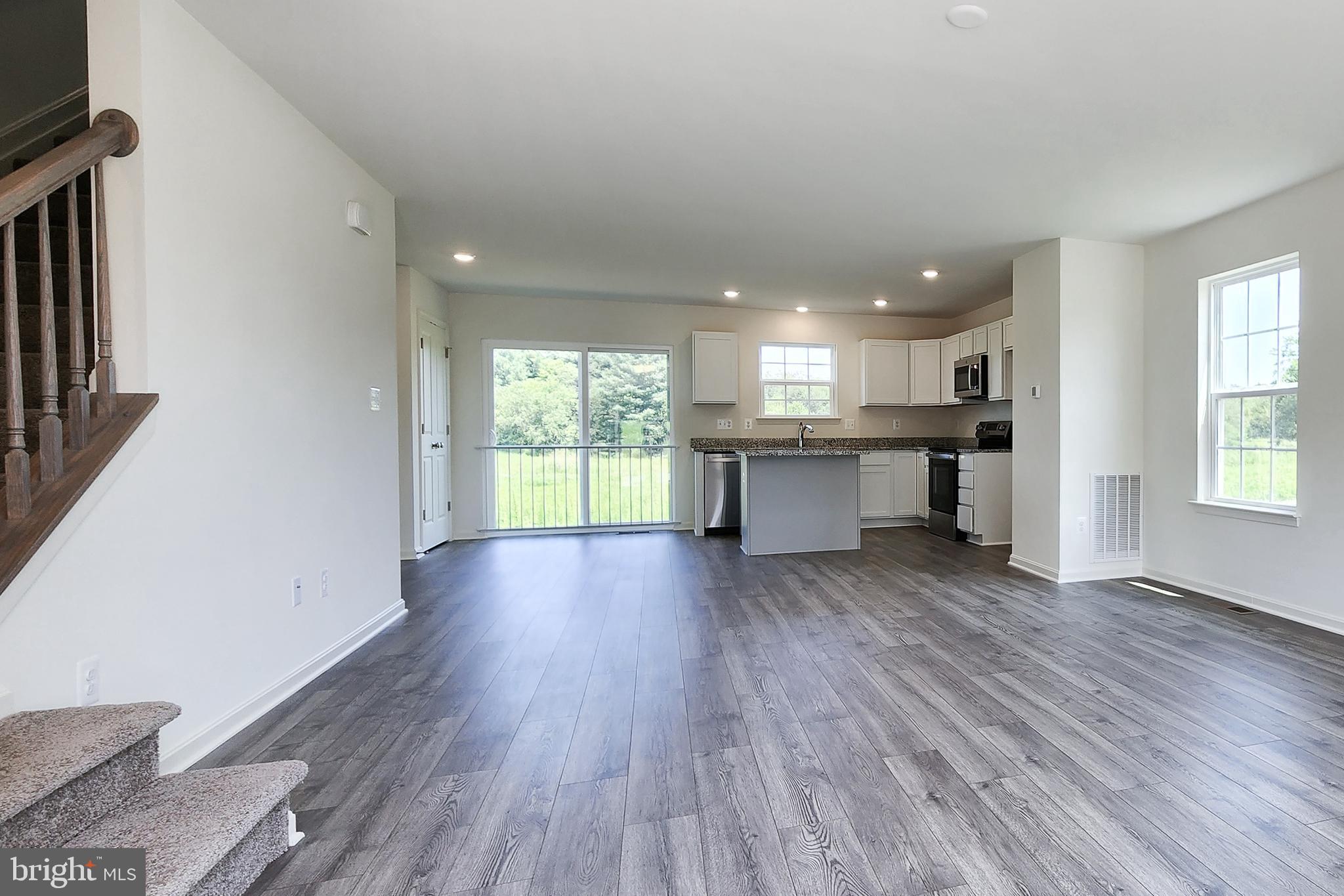 5385 Harrier Way Waynesboro, PA 17268 - Photo 7 of 23 a view of a kitchen and an empty room with wooden floor and a window