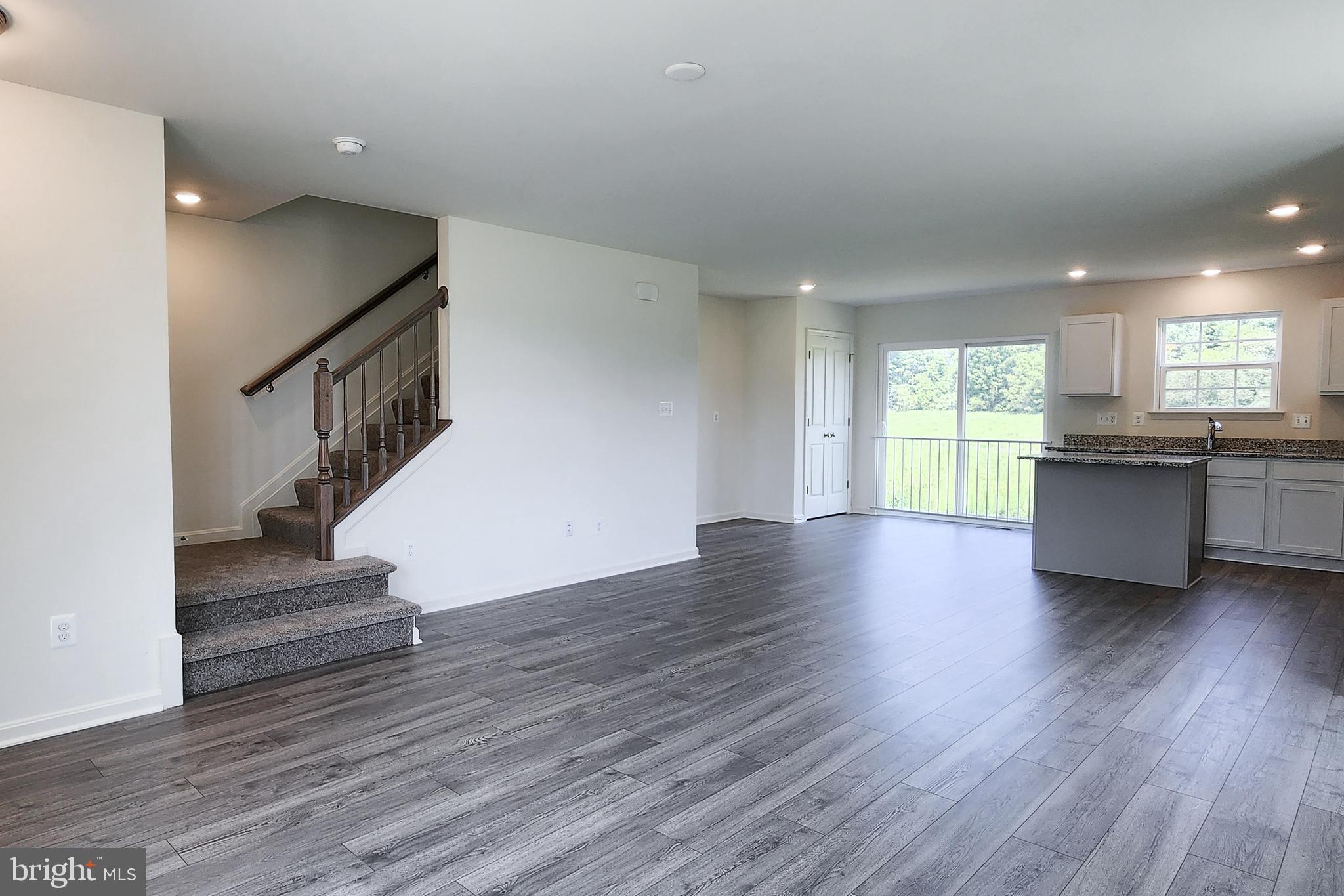 5385 Harrier Way Waynesboro, PA 17268 - Photo 9 of 23 a view of a kitchen and an empty room with wooden floor and a window