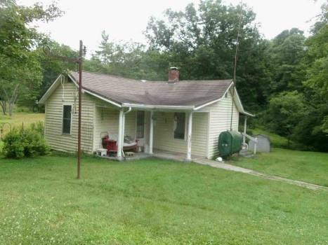 a view of a house with a yard and sitting area