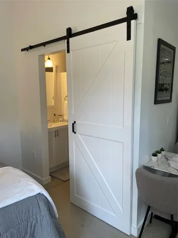 a bedroom with a bed a lamp and a potted plant