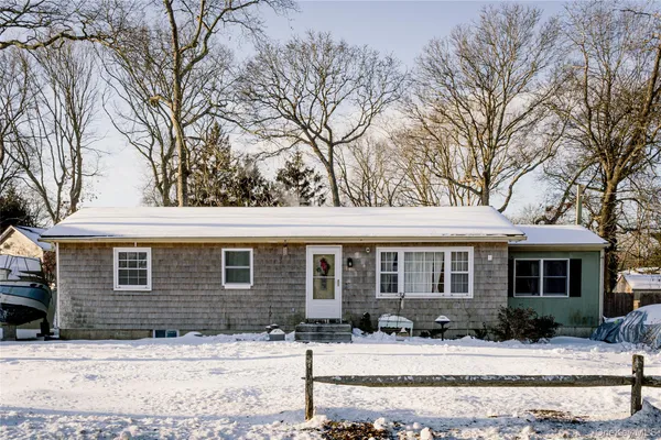 a front view of a house with yard covered in snow