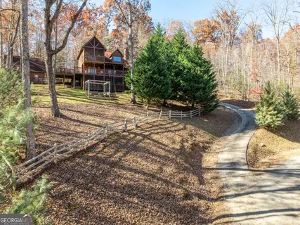 a view of backyard with wooden fence and large trees