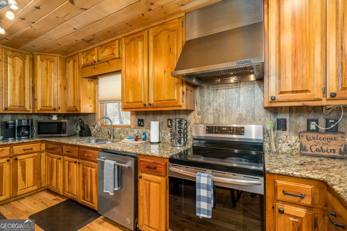 165 Christian Crossing, Unit 15 Morganton, GA 30560 - Photo 29 of 58 a kitchen with stainless steel appliances granite countertop a stove a sink and a microwave