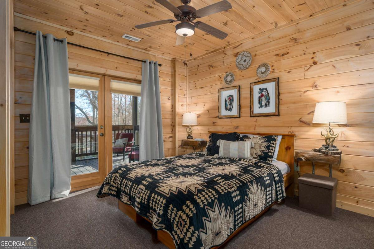 165 Christian Crossing, Unit 15 Morganton, GA 30560 - Photo 47 of 58 a bedroom with a bed and a chandelier