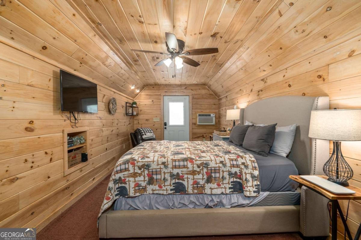 165 Christian Crossing, Unit 15 Morganton, GA 30560 - Photo 56 of 58 a bedroom with a large bed and a flat tv screen on dresser