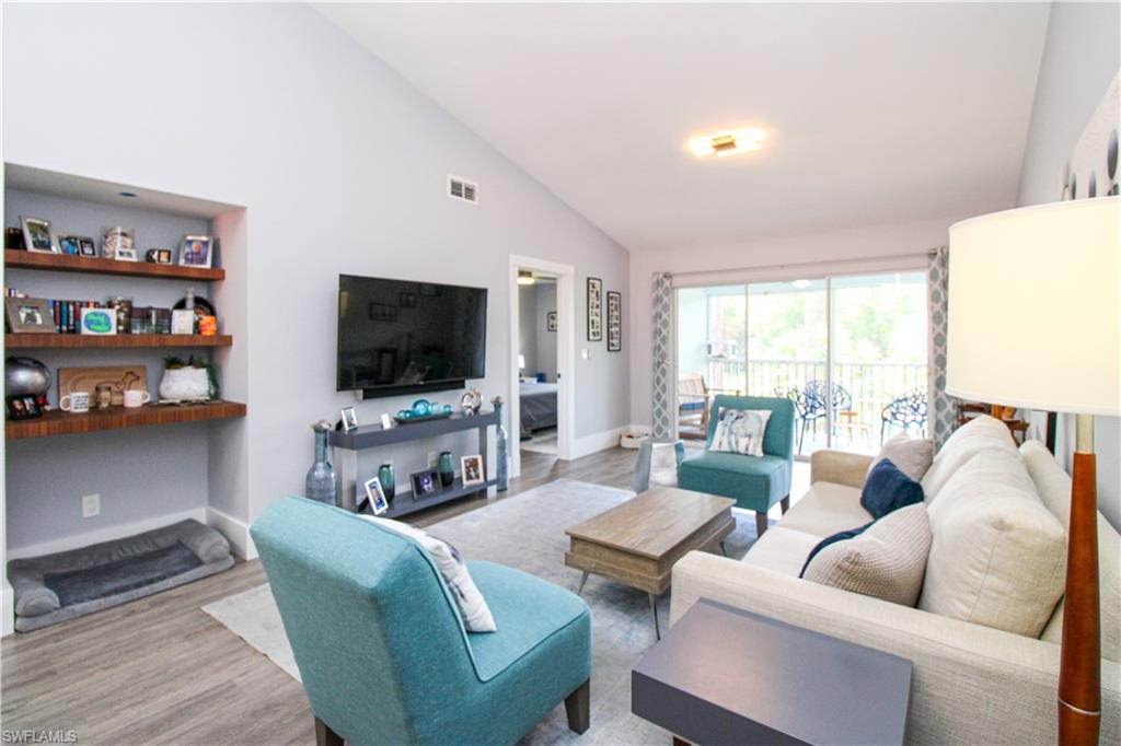 225 Robin Hood Circle, Unit 203 Naples, FL 34104 - Photo 20 of 50 Living room with high vaulted ceiling and hardwood / wood-style floors