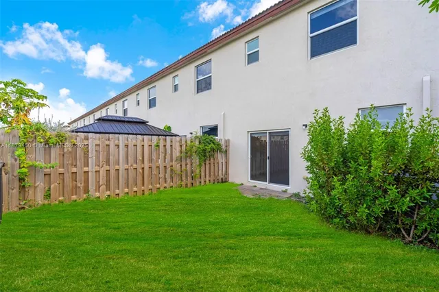 a view of a patio with couches table and chairs and potted plants