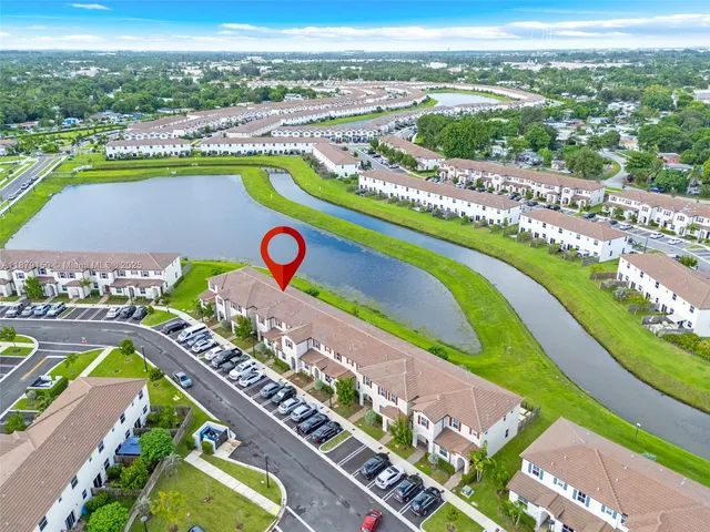 an aerial view of a swimming pool a playground lake and mountain view in back