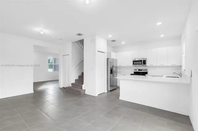 a kitchen with stainless steel appliances a refrigerator sink and microwave