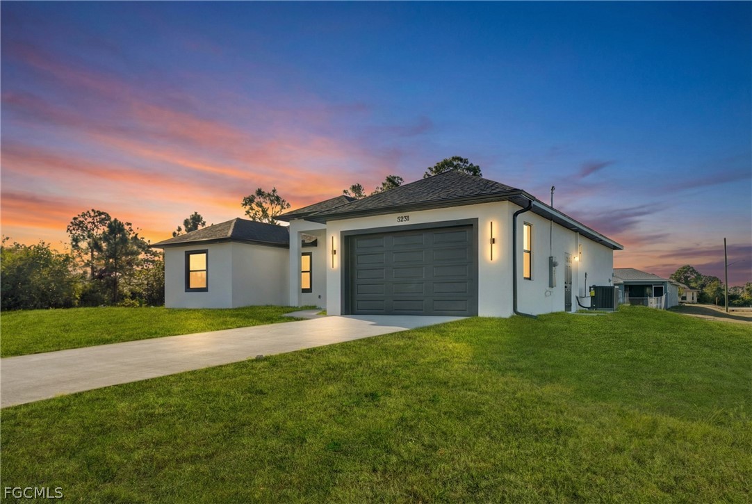5231 6th Street West Lehigh Acres, FL 33971 - Photo 1 of 26 a front view of a house with a yard and garage
