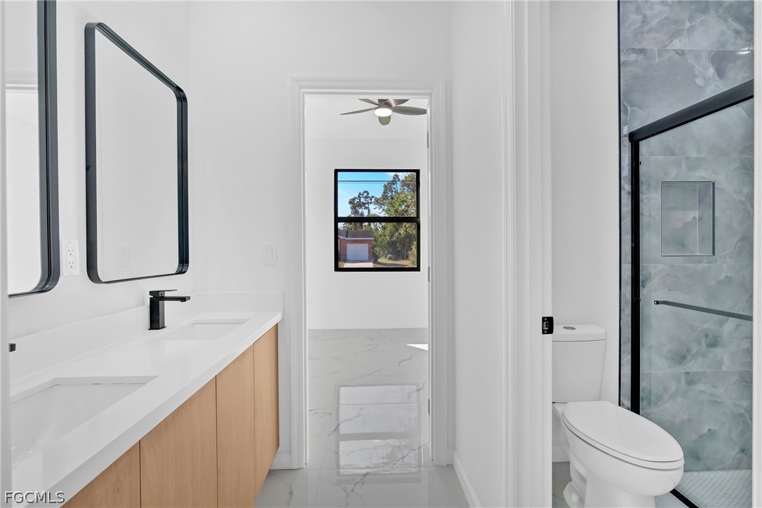 5231 6th Street West Lehigh Acres, FL 33971 - Photo 12 of 26 a bathroom with a double vanity sink toilet and shower