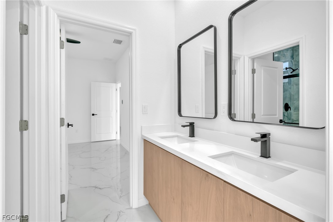 5231 6th Street West Lehigh Acres, FL 33971 - Photo 14 of 26 a bathroom with a double vanity sink mirror and