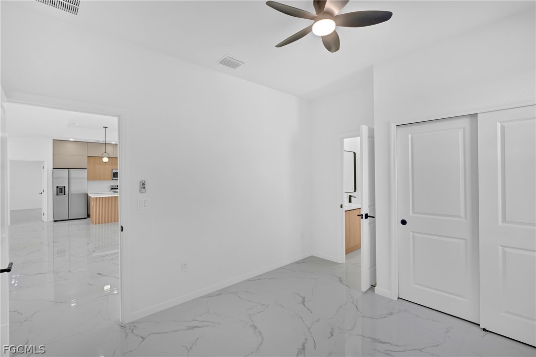 5231 6th Street West Lehigh Acres, FL 33971 - Photo 16 of 26 a view of a livingroom with a chandelier fan and kitchen view